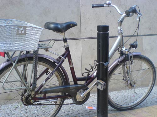 Fahrrad, an einem halbhohen Pfosten angeschlossen