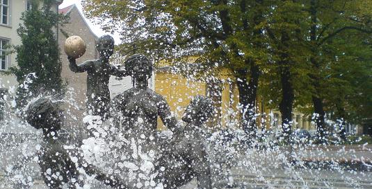 Detailaufnahme vom Brunnen der Lebensfreude: Figuren hinter Wasserstrahlen und Tropfen