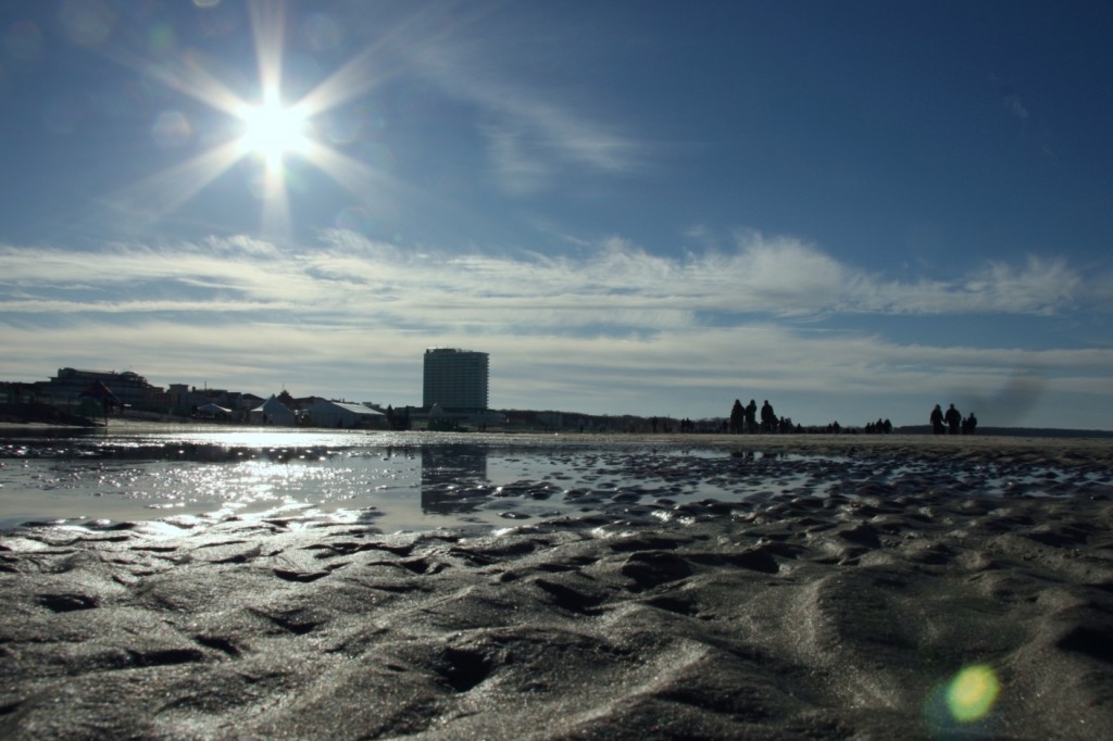 Sonne spiegelt sich in Wasserlache am Strand