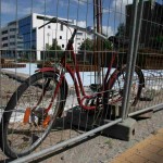 rotes altes Fahrrad am Bauzaun