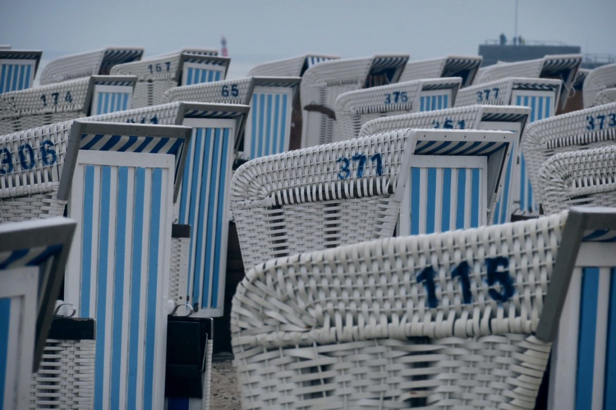 verschlossene Strandkörbe mit blauweiß gestreiften Verschlägen.